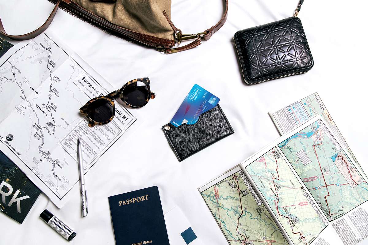 Maps, a passport and American Express Hilton Honors card on a table