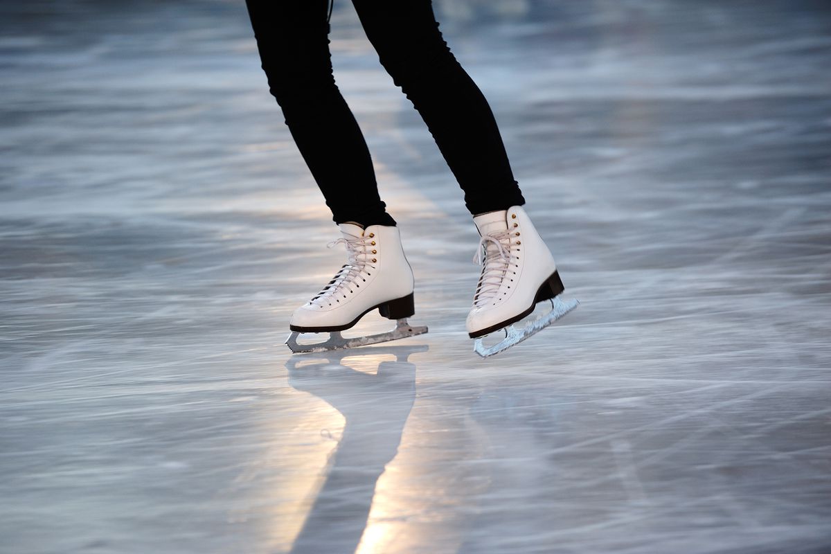 Gild with white skates on ice.