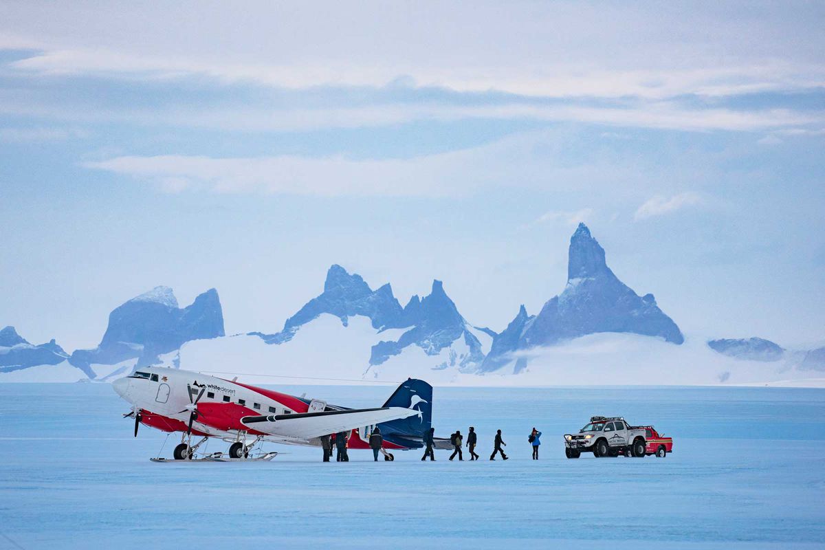A red and white plane in a frozen/snowy landscape