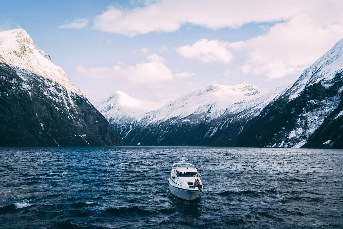 A boat sailing through a fjord in Norway