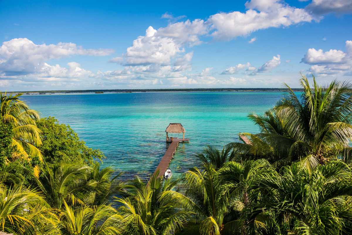 Aerial view of palm trees and blue water at Bacalar Lake, Quintana Roo Mexico, Riviera Maya.