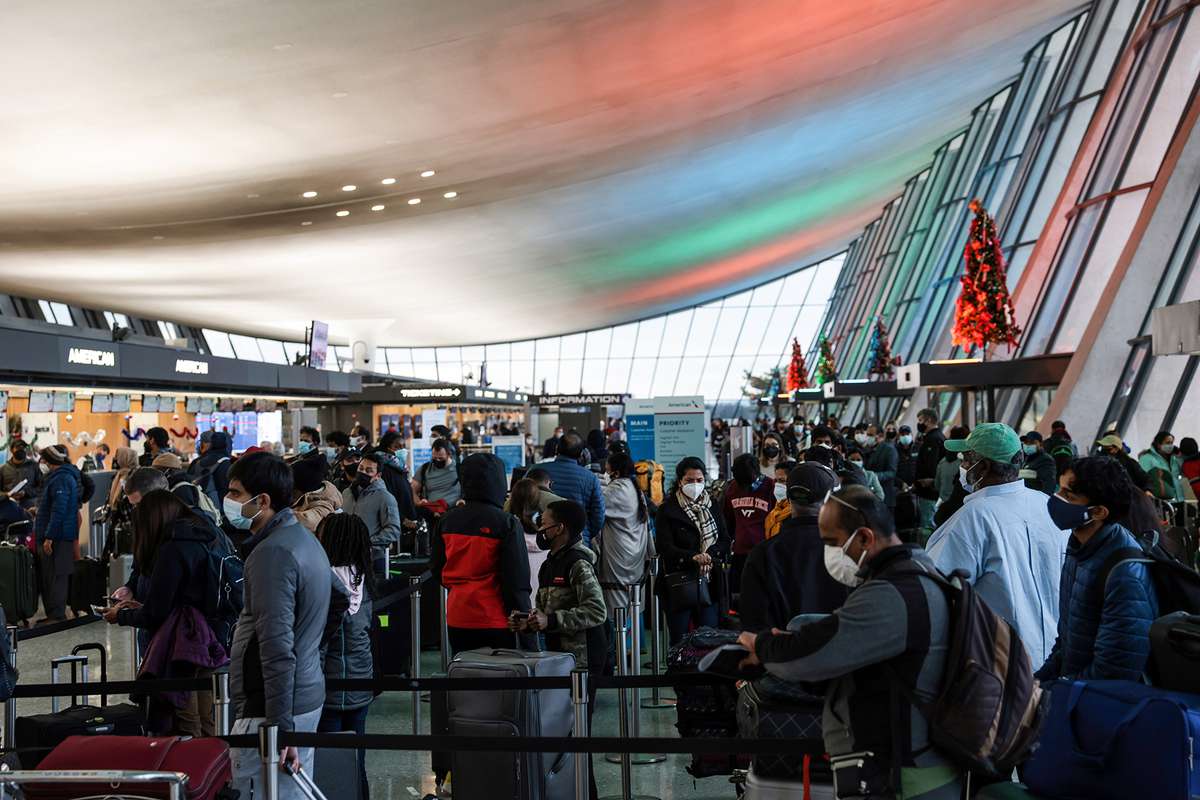 Passengers wait in line to check in for their flight at the Dulles International Airport