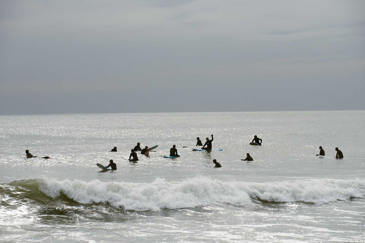 Surfers in winter wetsuits waiting in the water in New York