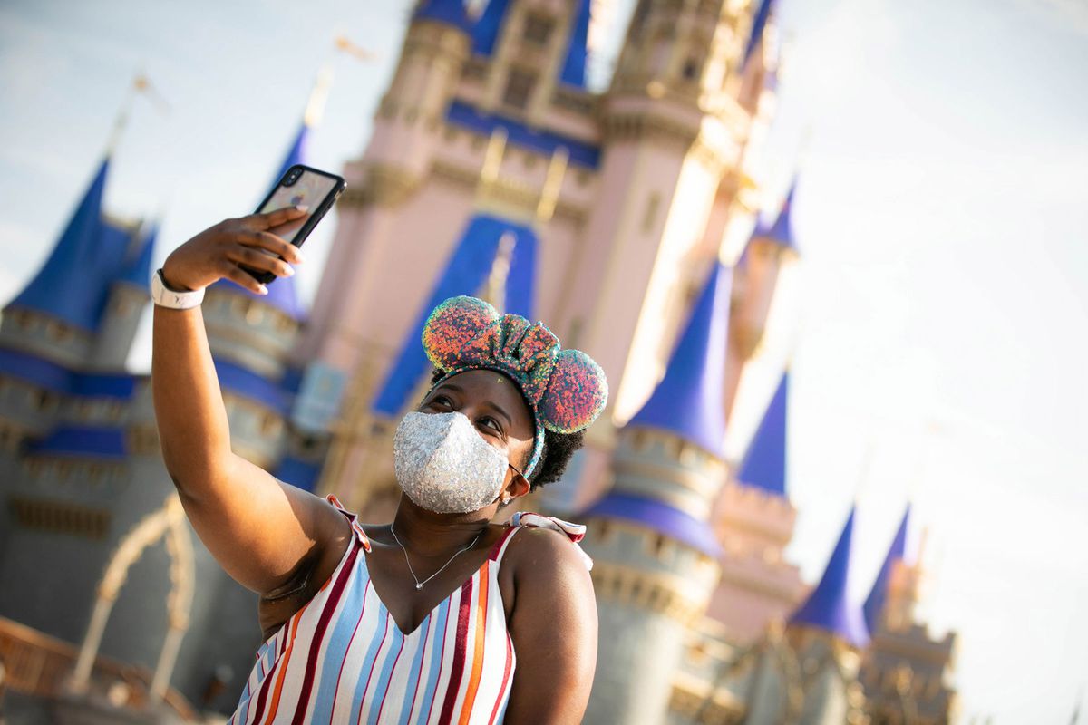 Disney World guest stops to take a selfie at Magic Kingdom Park at Walt Disney World Resort
