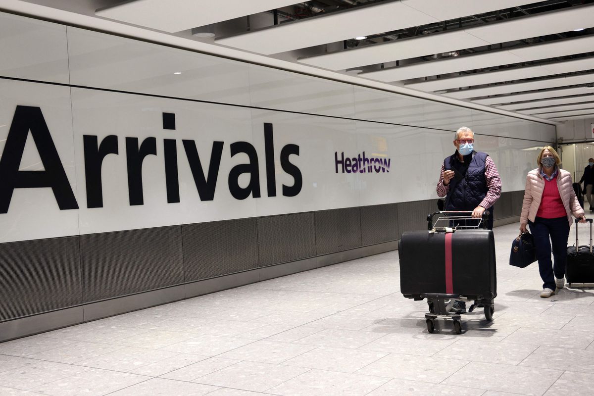 People wearing facemaks arrive at Heathrow's Terminal 5