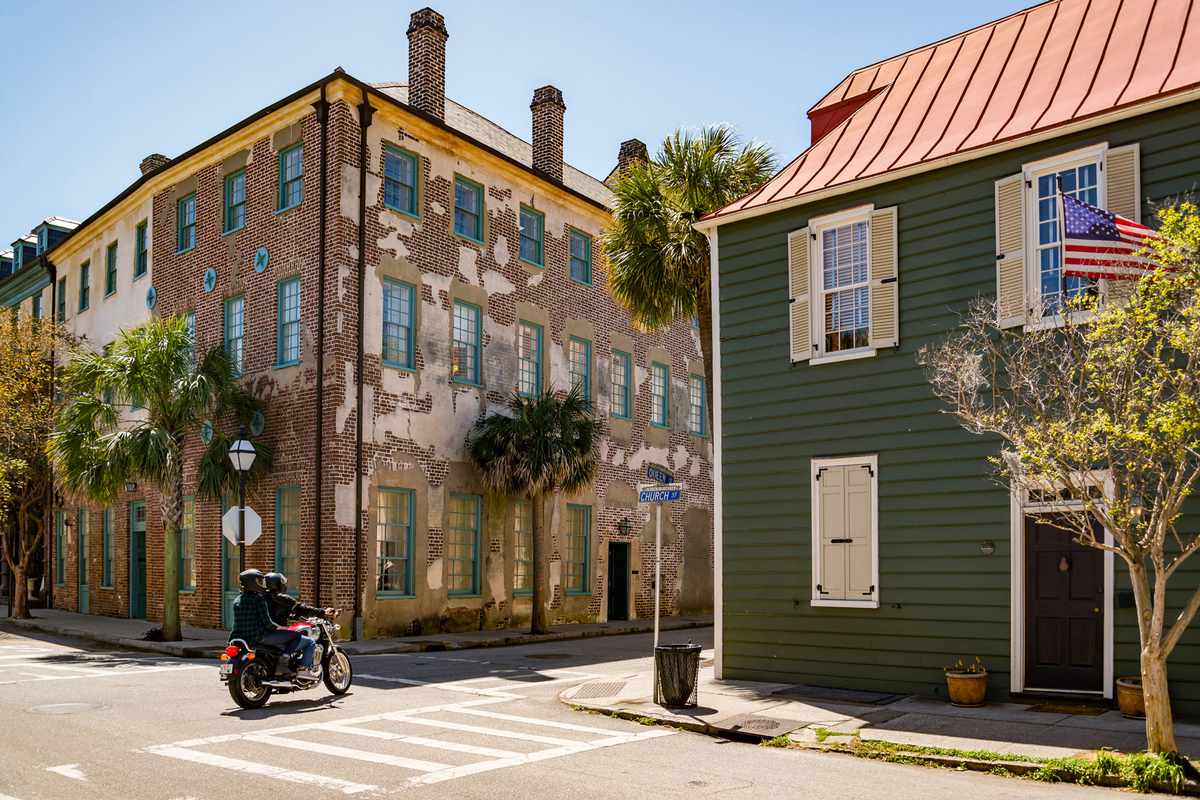 Two people ride motorbike in historical downtown area of Charleston, South Carolina, USA
