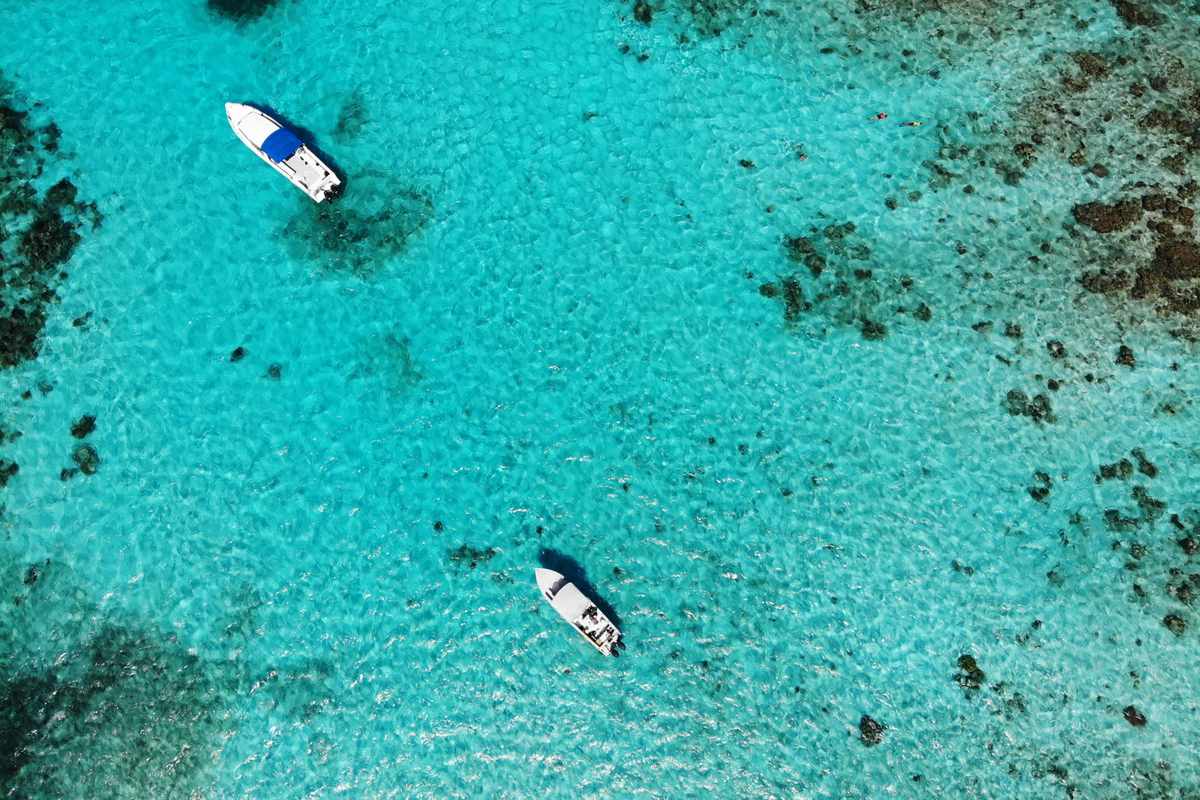 Aerial view of two boats in turquoise blue water in Belize