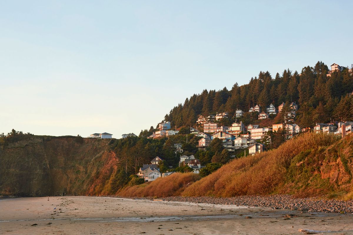 Low angle view of the a small ocean town built into the hill along the coast in Oregon at sunset.