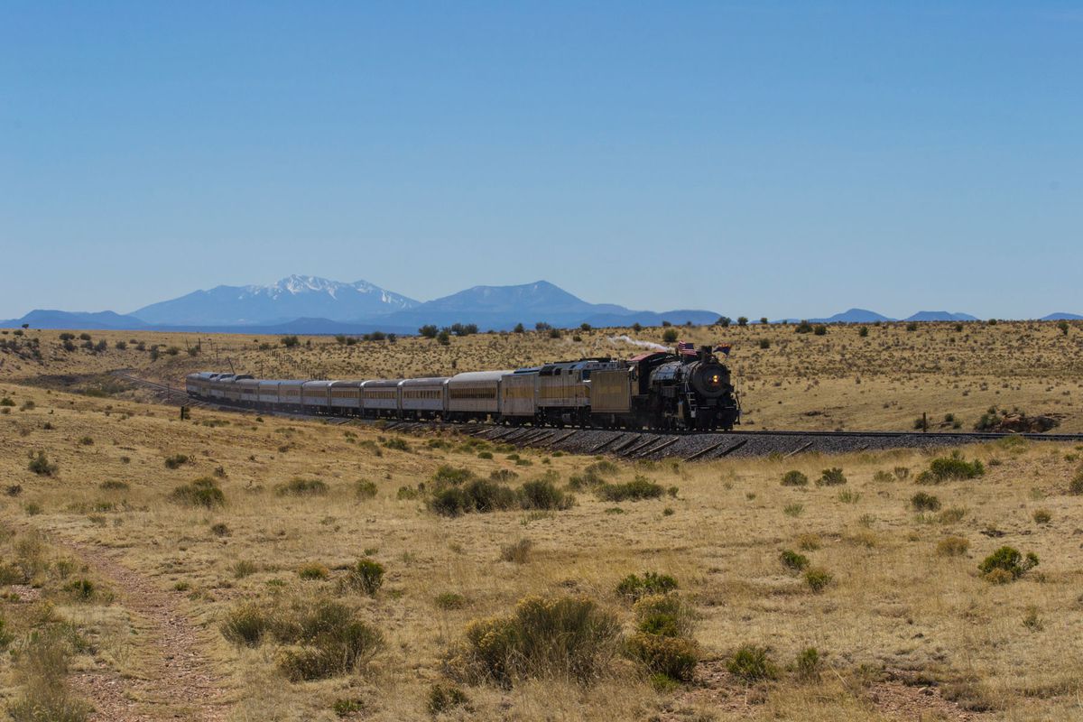 Grand Canyon Railway steam engine in the landscape with mountains in the distance