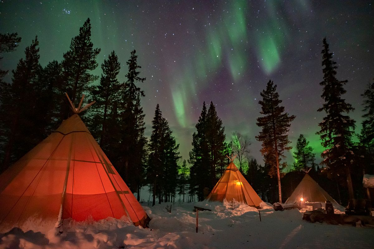 Sami lavvu (traditional lodging) under northern lights
