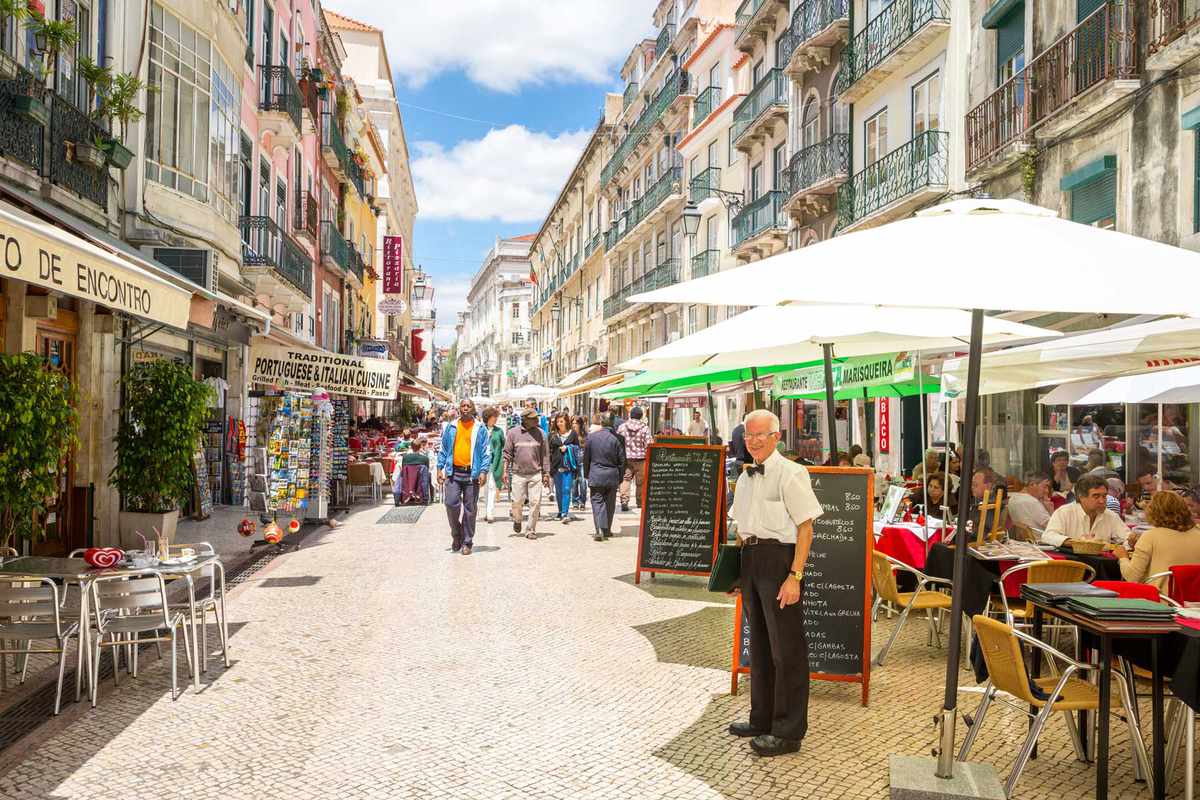 Tourists are walking at Santo Antao street in Lisbon ,Portugal. Santo Antao street is a lively pedestrian street known for its seafood restaurants.