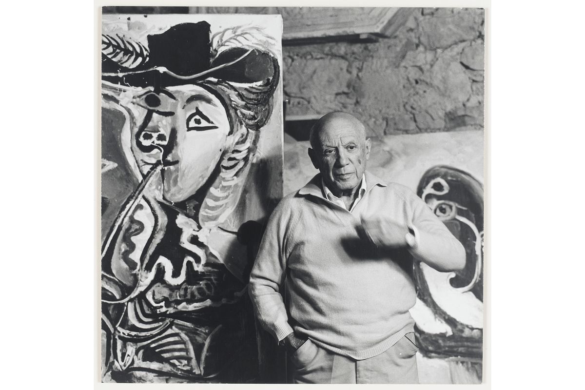 Pablo Picasso posing next to his painting, Couple
