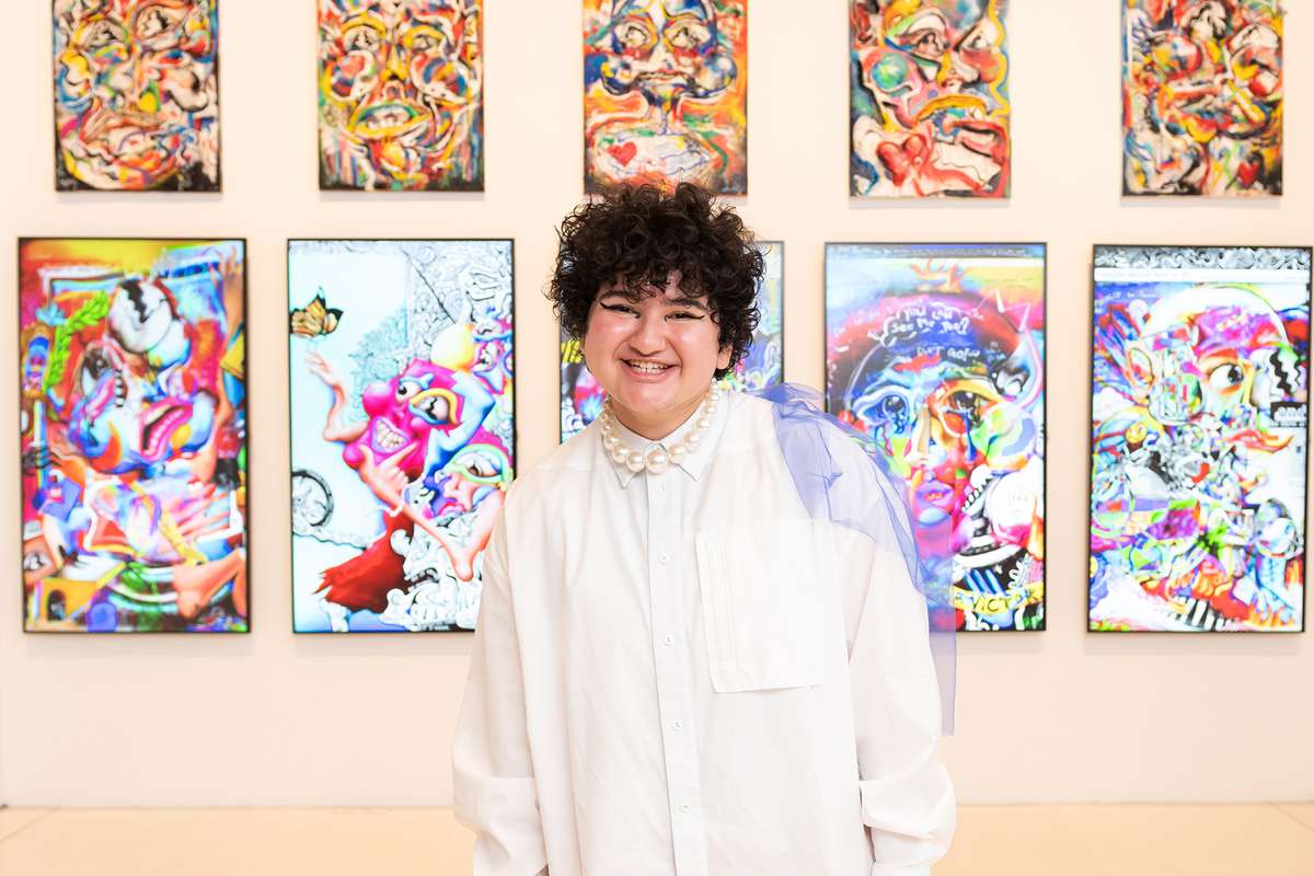 Digital artist FEWOCiOUS in front of a collection titled "Hello, i’m Victor (FEWOCiOUS) and This Is My Life"