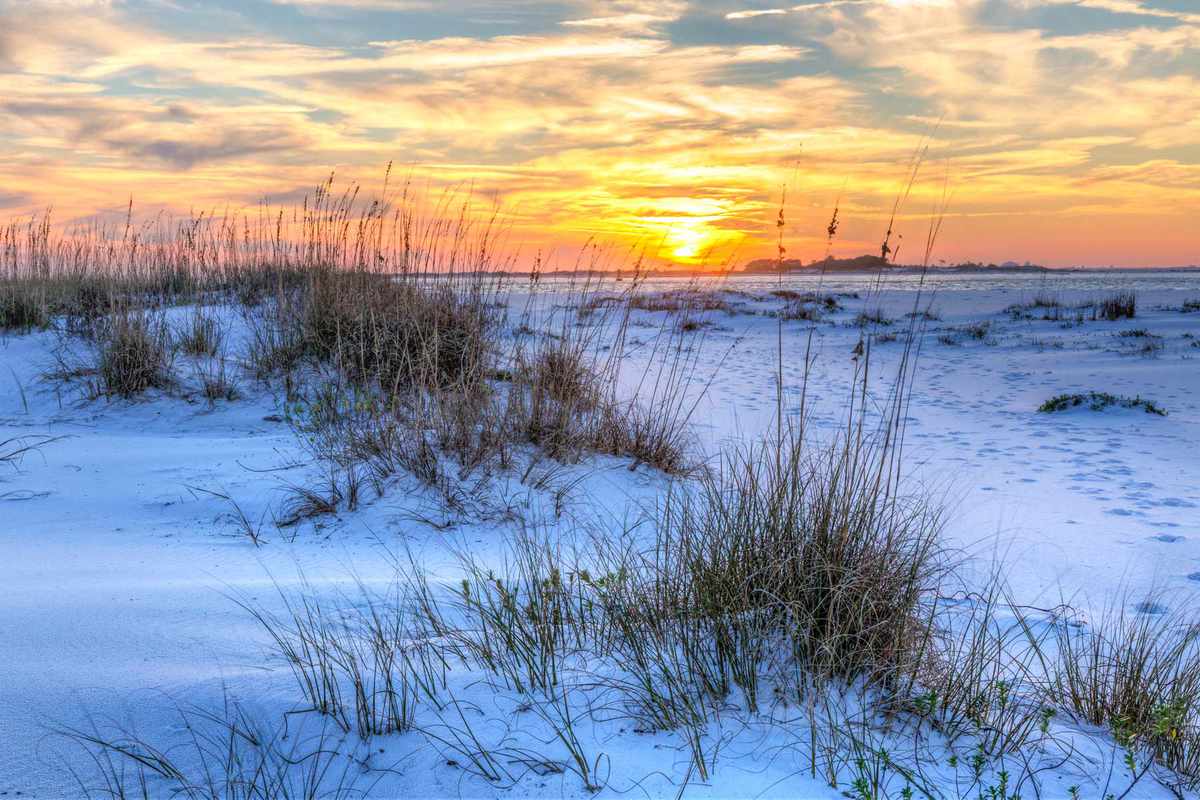A colorful sunset over the seaoats and dunes on Fort Pickens Beach in the Gulf Islands National Seashore, Florida.