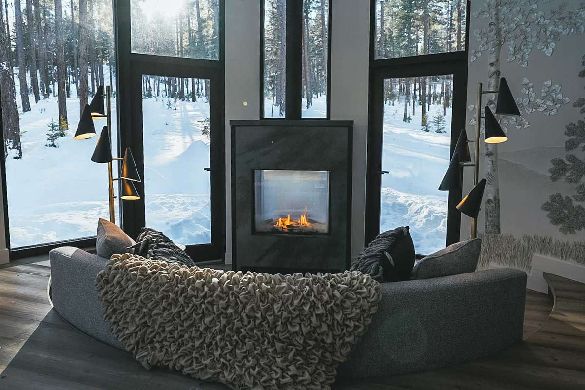 Round Haus interior living room with cozy fireplace and large windows at Green O resort in Montana