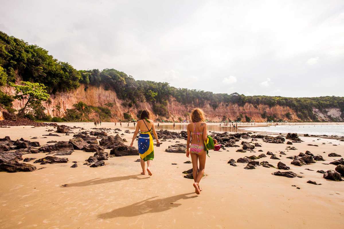 A group of people walking on Praia de Pipa Brazil.