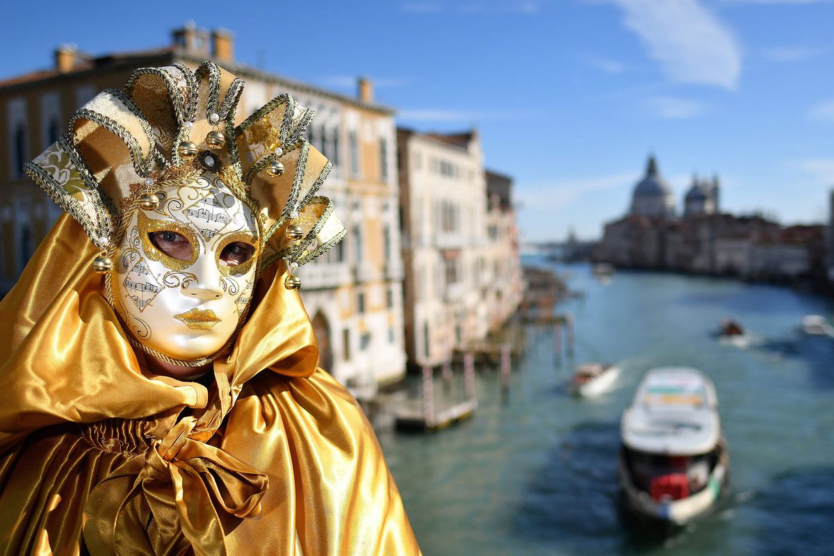 A reveller wearing a mask and a period costume takes part in the Venice Carnival