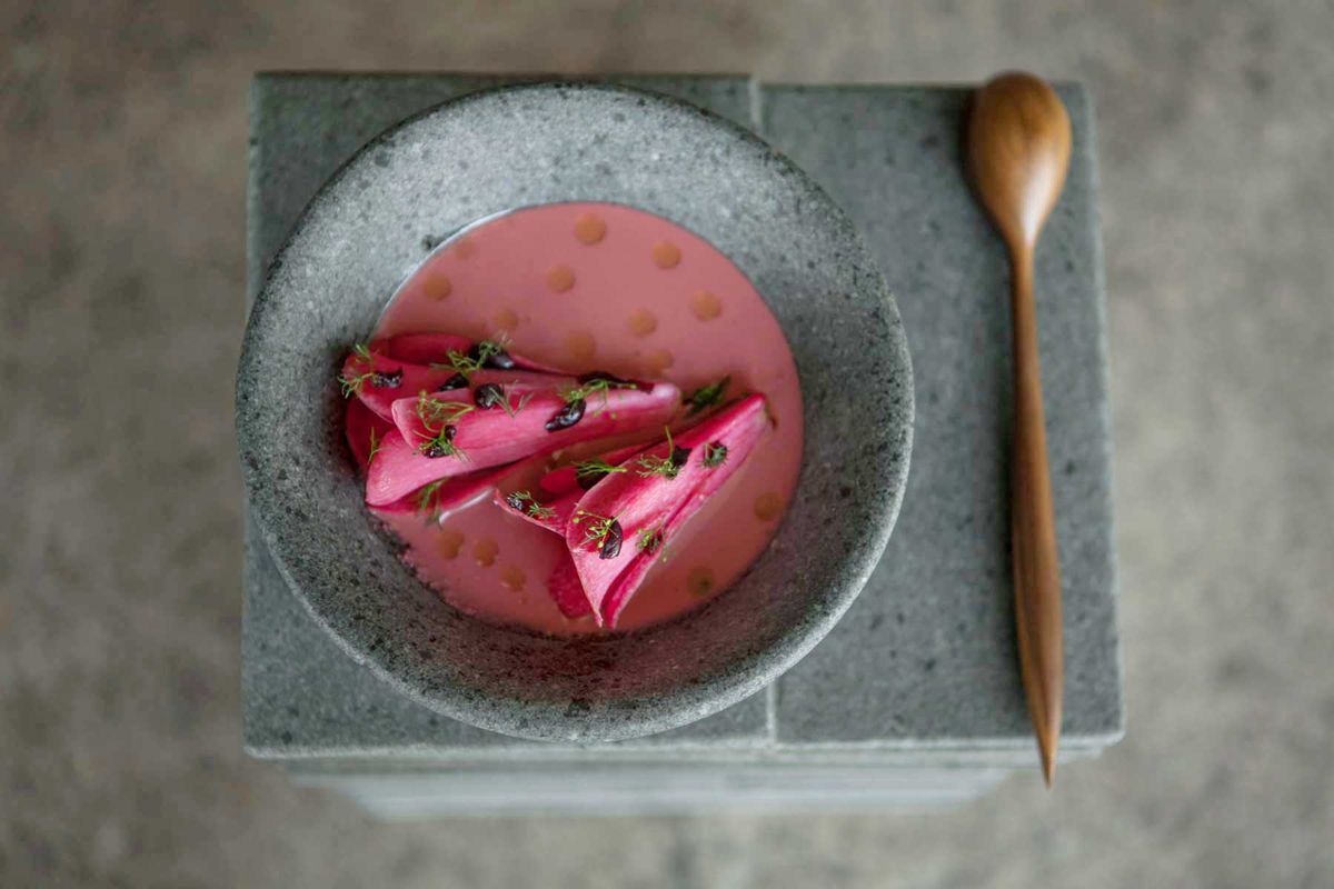 A pink broth dish in a grey stone bowl