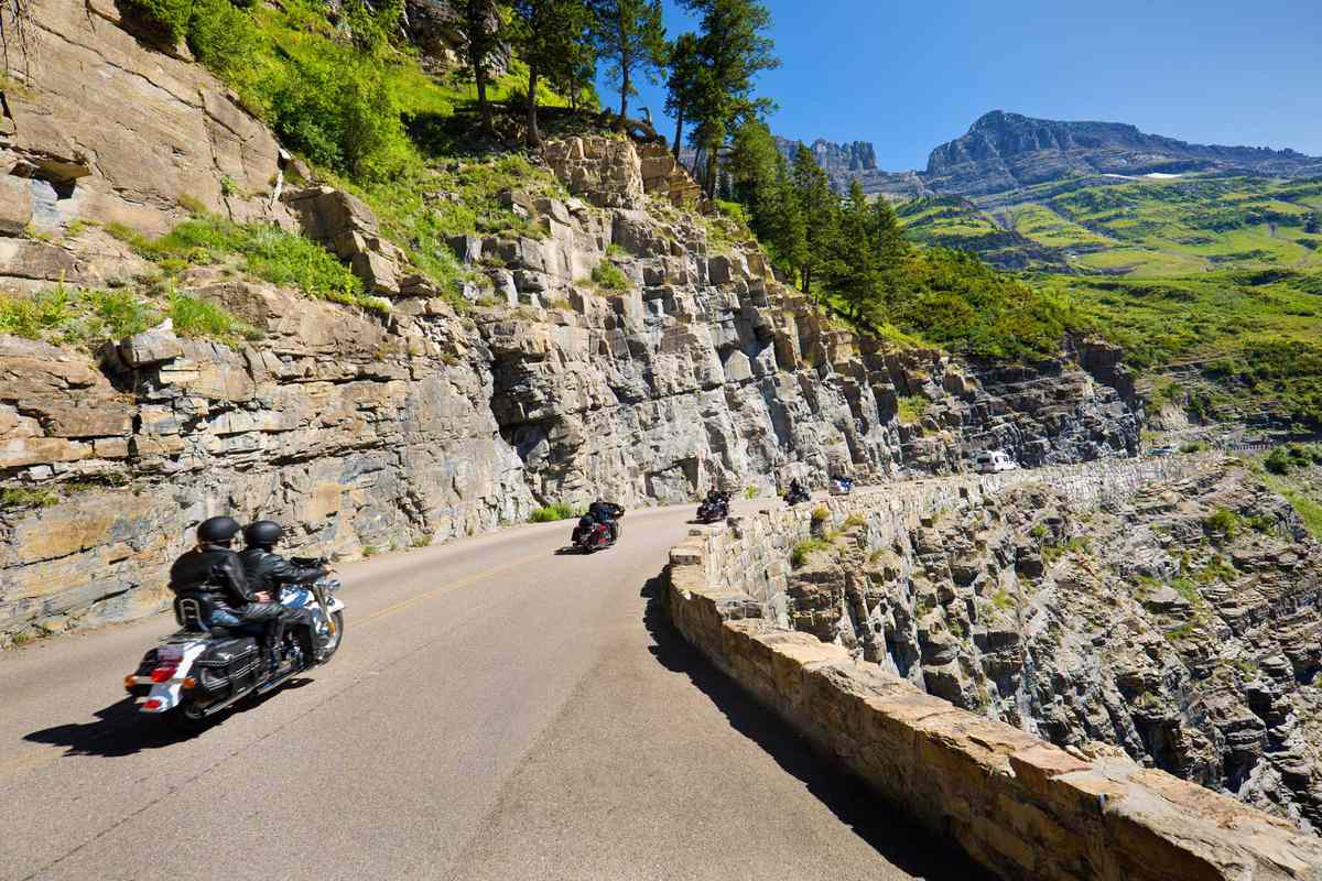 A group of motorcycle tourists visiting the Glacier National Park in Montana, USA. Glacier National Park, a beautiful tourist destination. The motorcyclists are driving on the scenic Going To The Sun Road at the park.