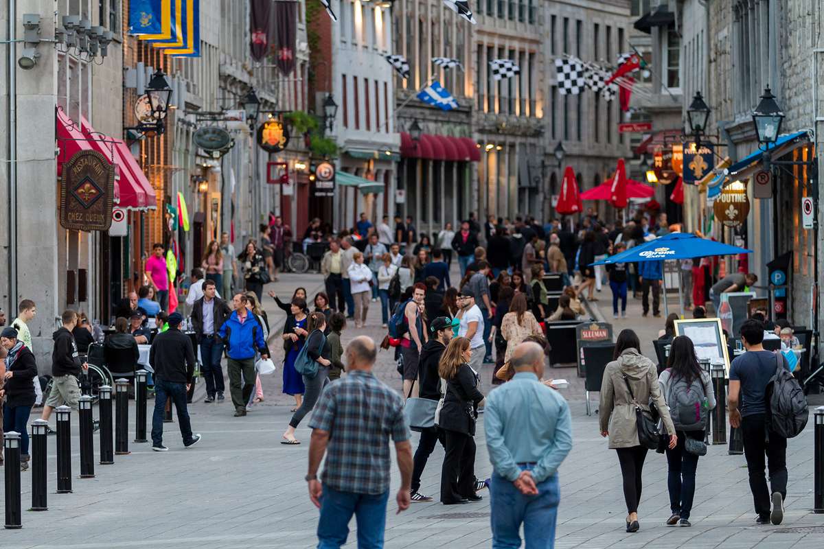 Crowds of people walking dow Old Montreal's famous St Paul street