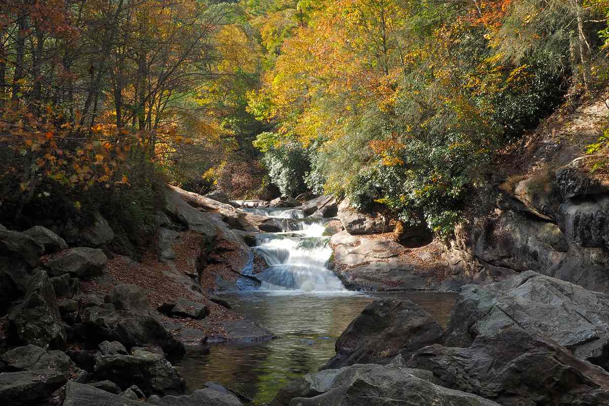 Quarry Falls (also know as Bust Your Butt Falls) as seen during the Autumn season with colorful foliage as a backdrop.