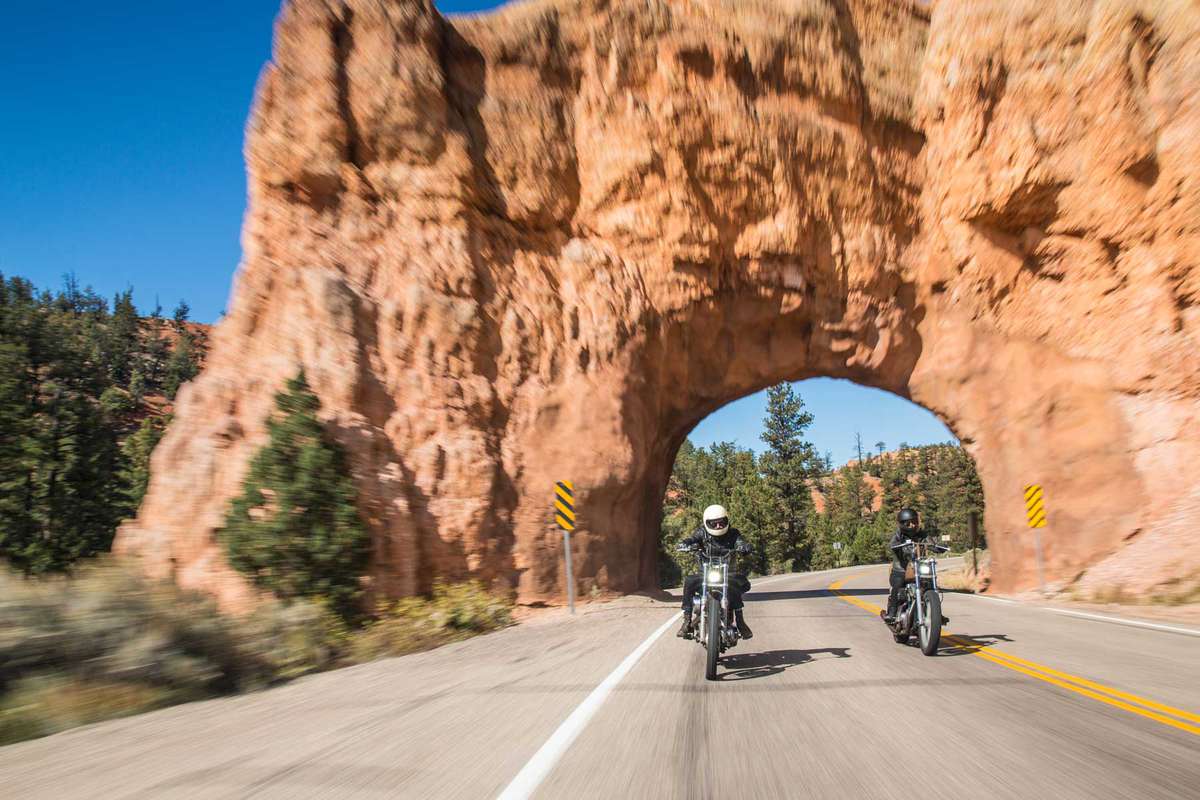 Two motorcyclists going through arched rock landscape on Highway 12 in Grand Staircase Escalante National Monument