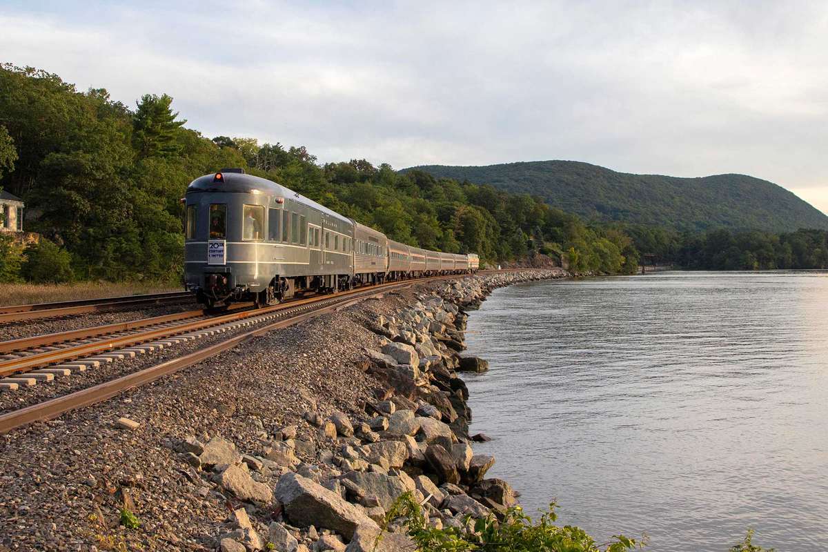 A 1940s passenger train goes along the Hudson River in NY State in modern day times