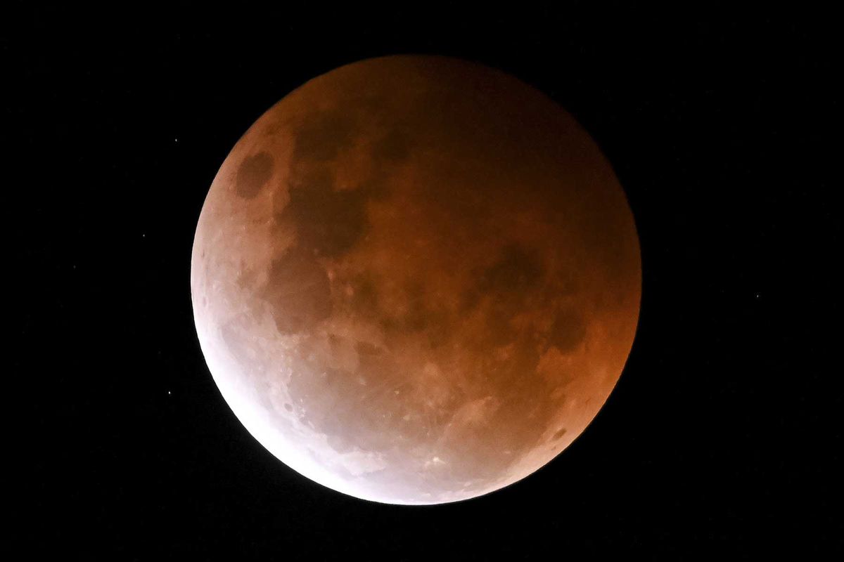 The full moon, known as a super flower blood moon, is seen during its maximum lunar eclipse phase, in Sydney, Australia, on May 26, 2021.