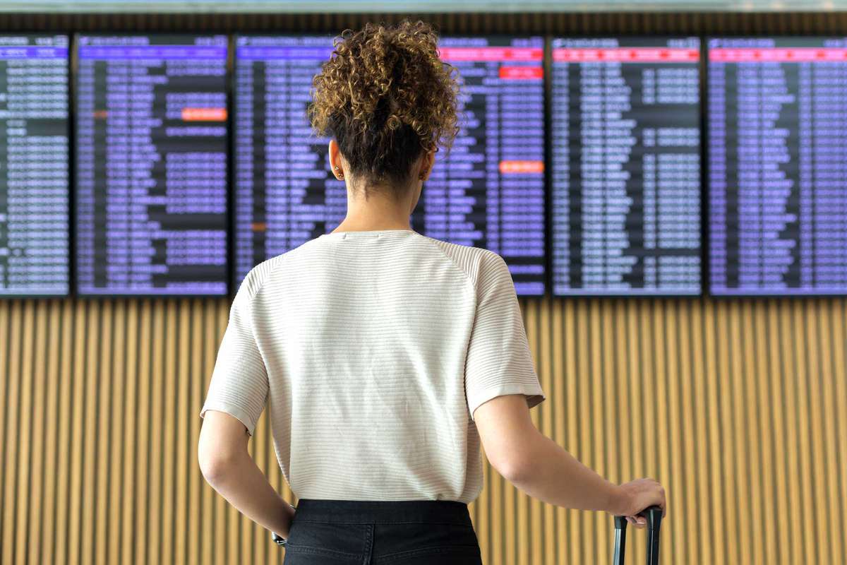 Young woman traveler looking at flight information