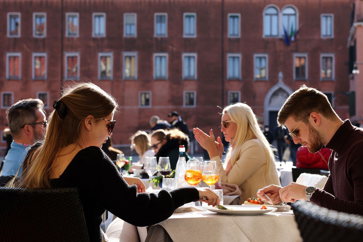 Tourists dine at a restaurant in Venice, Italy.
