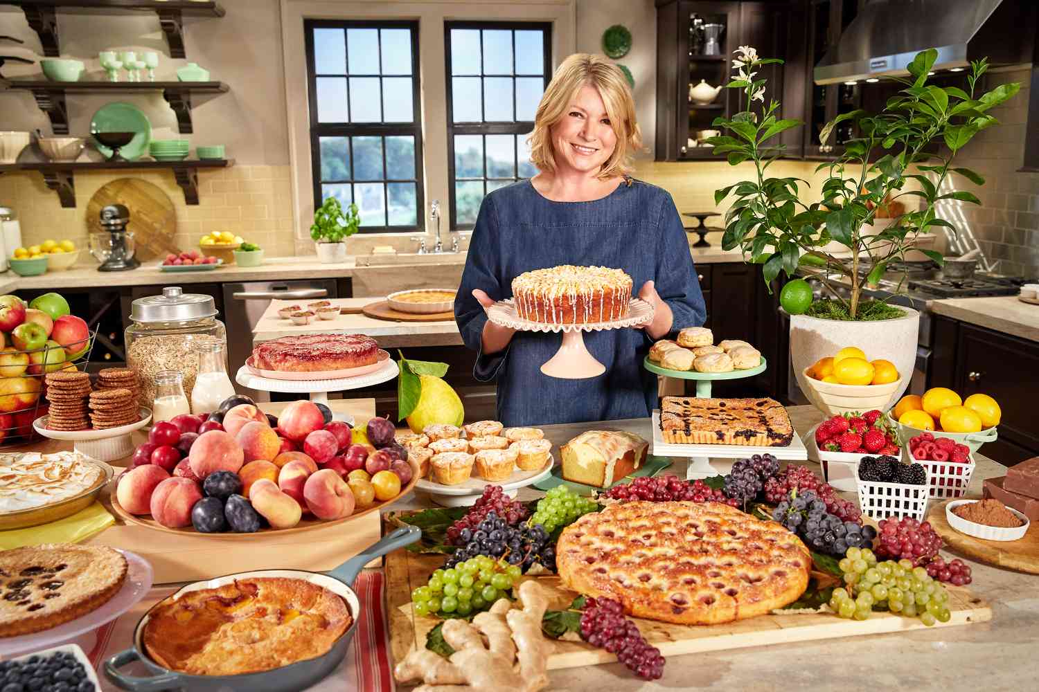 martha in kitchen holding cake surrounded by desserts