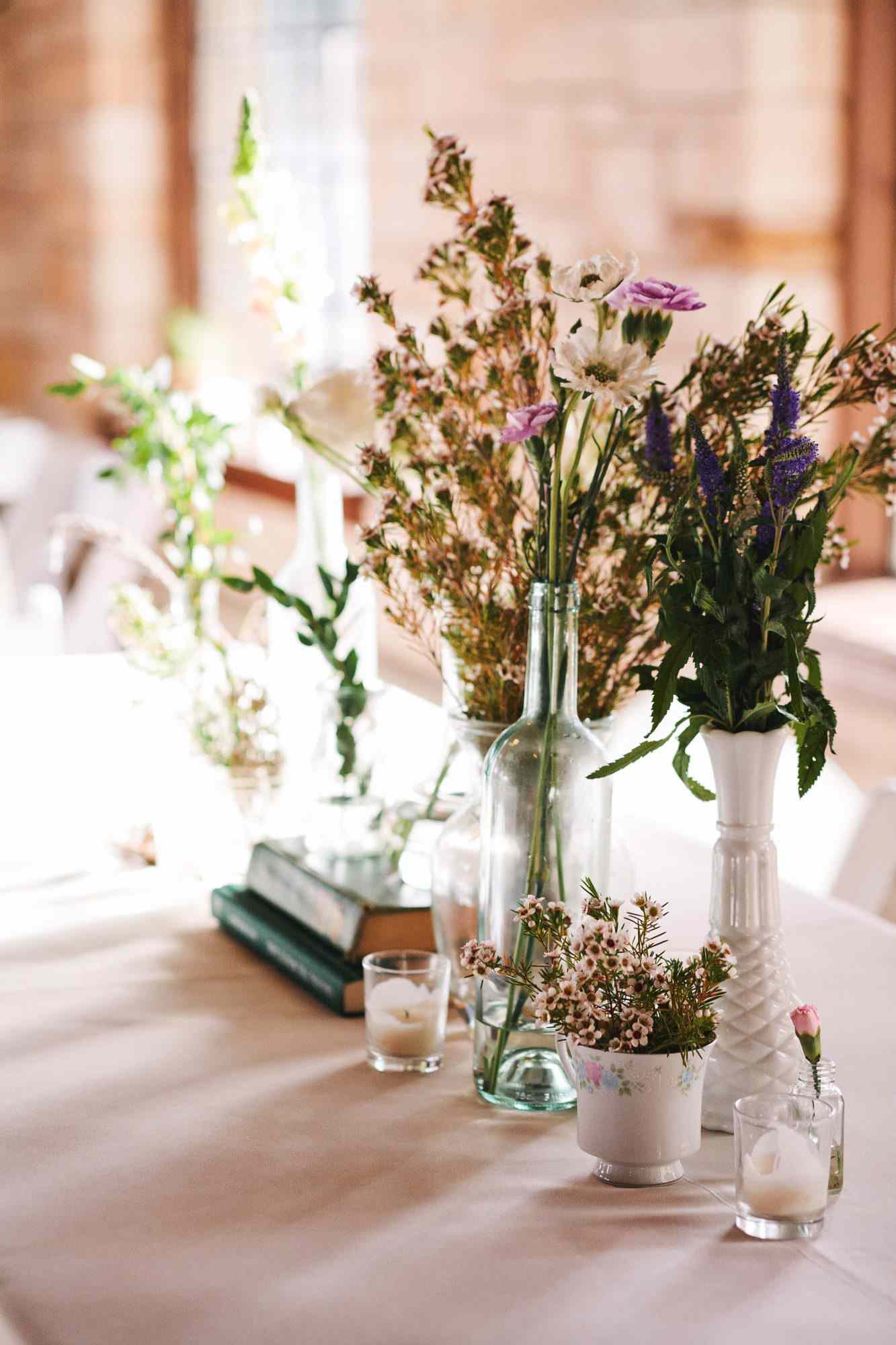 wedding centerpiece white vases candles purple flowers