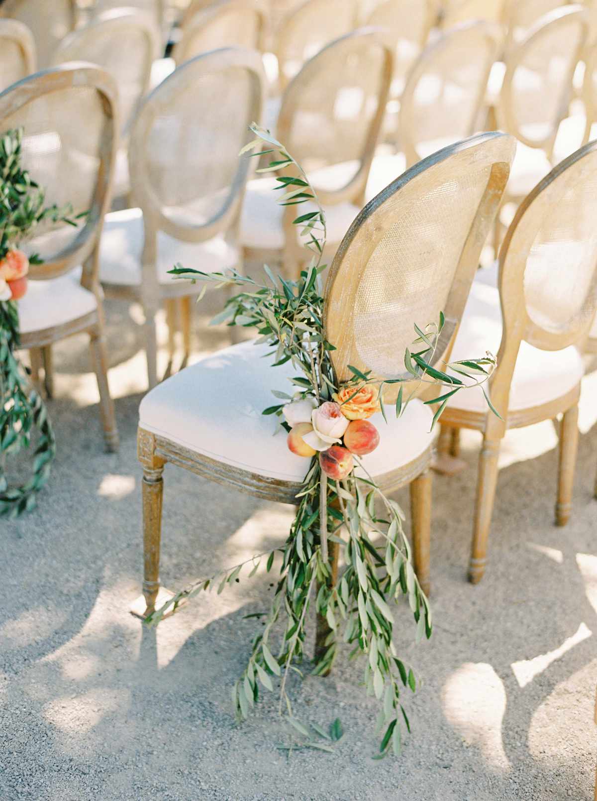 outer aisle chairs decorated with roses peaches and olive branches