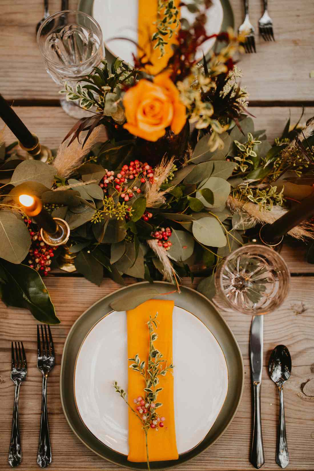 orange accented place setting with floral centerpiece