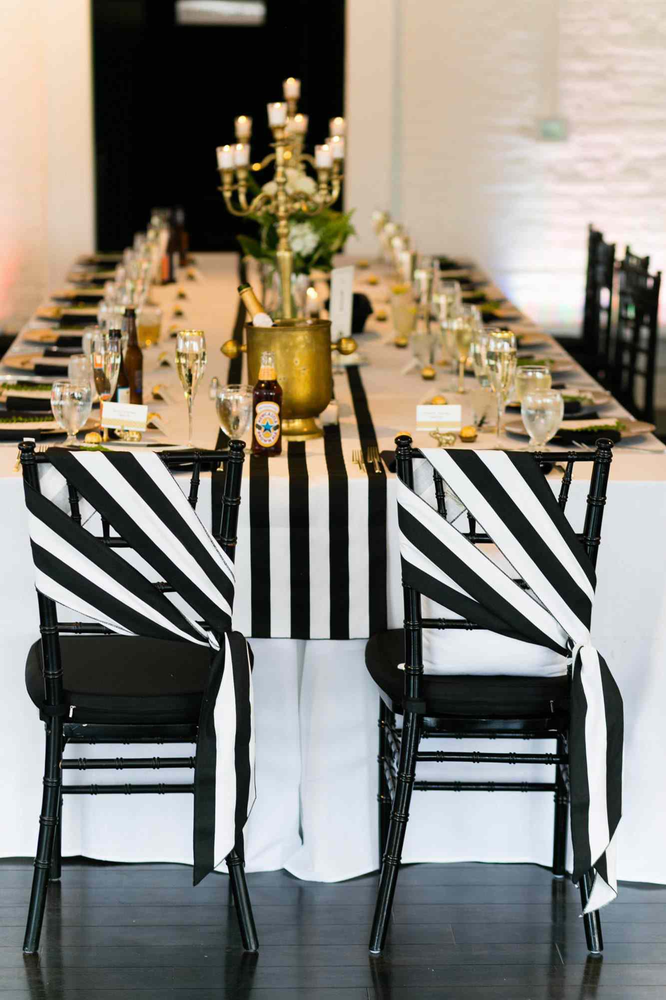 striped sashes on black chairs at reception table