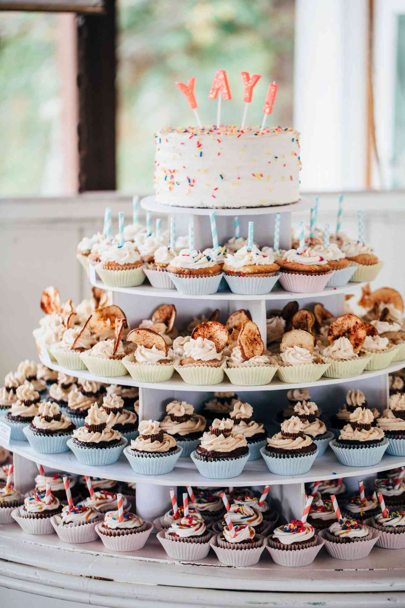 four tiered cupcake stand with mini cake on top