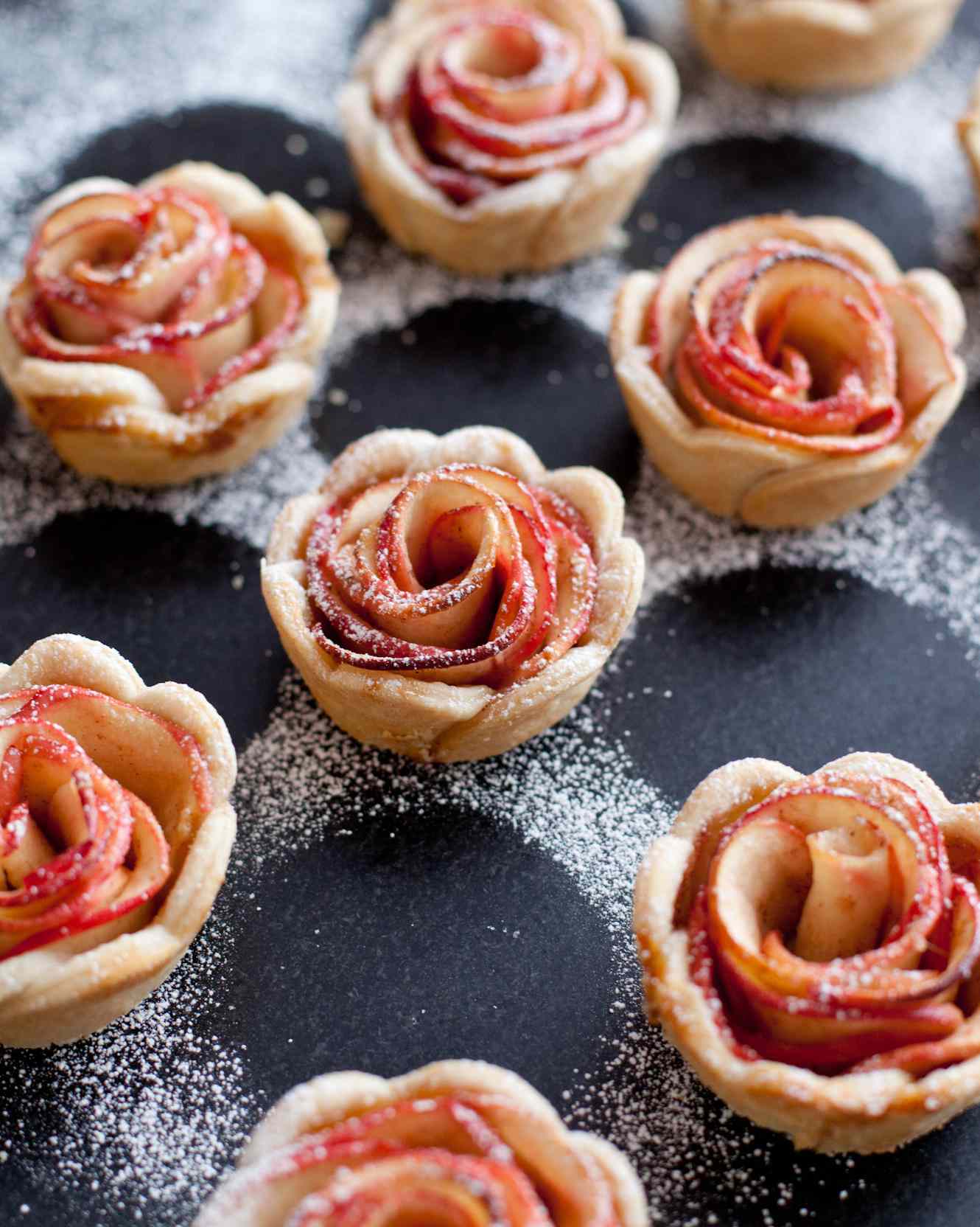 Dust mini rose apple pies with powdered sugar
