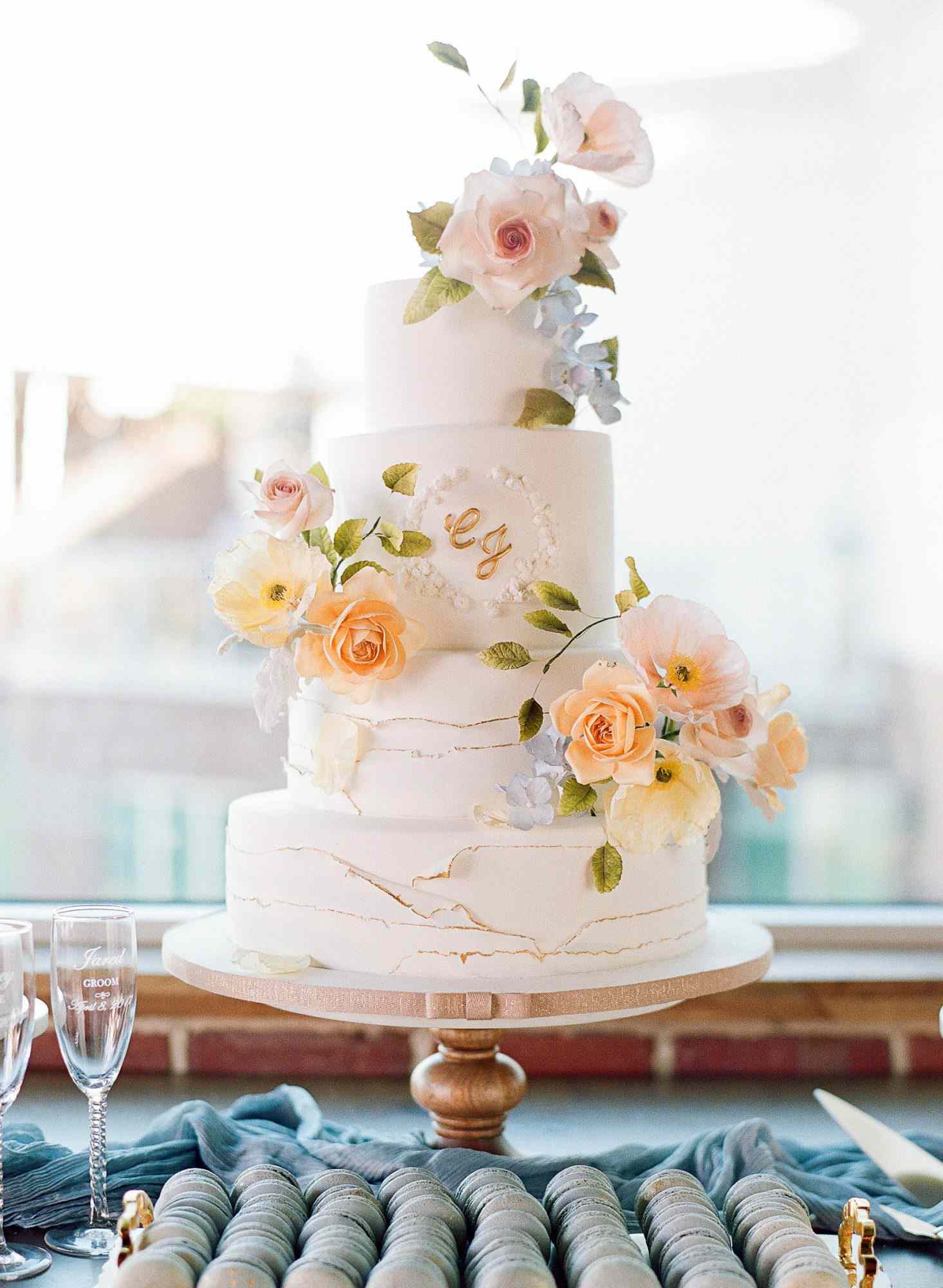 <p>Jonathan Caleb Cake used realistic sugar flowers—insect nibbles and all—to decorate this cake, which was served at a flower-filled, garden wedding.</p>

