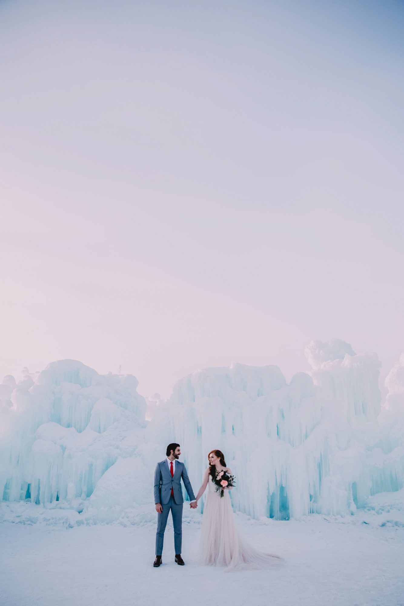 Bride and Groom Posing with Ice Castle