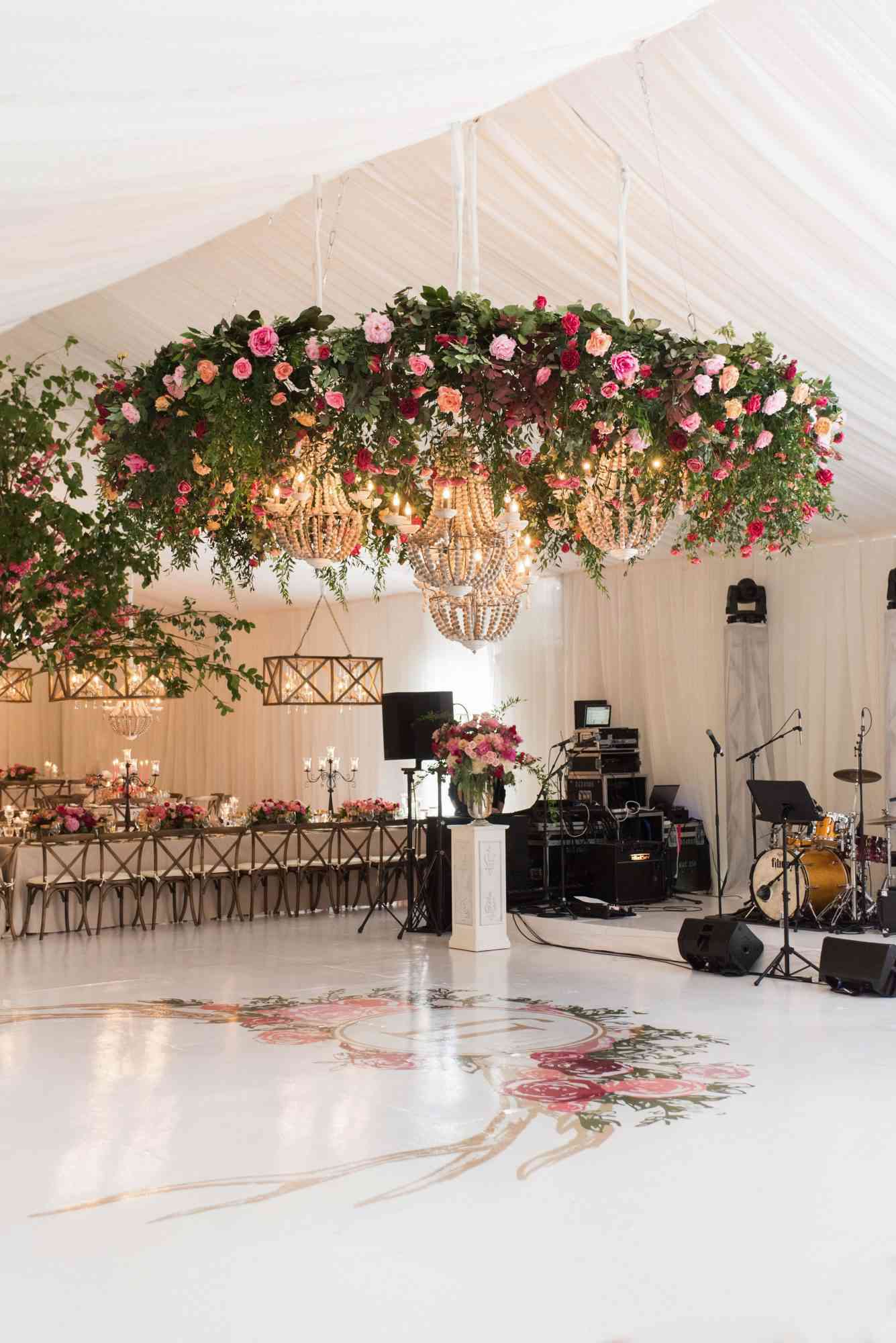 wedding chandelier with roses and greenery wood beams