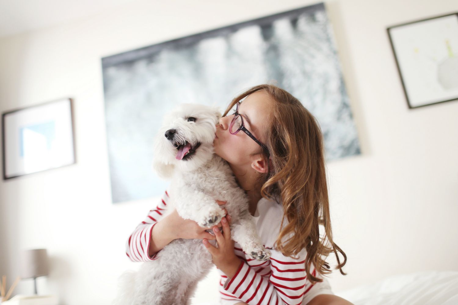 Young girl giving her pet dog a kiss