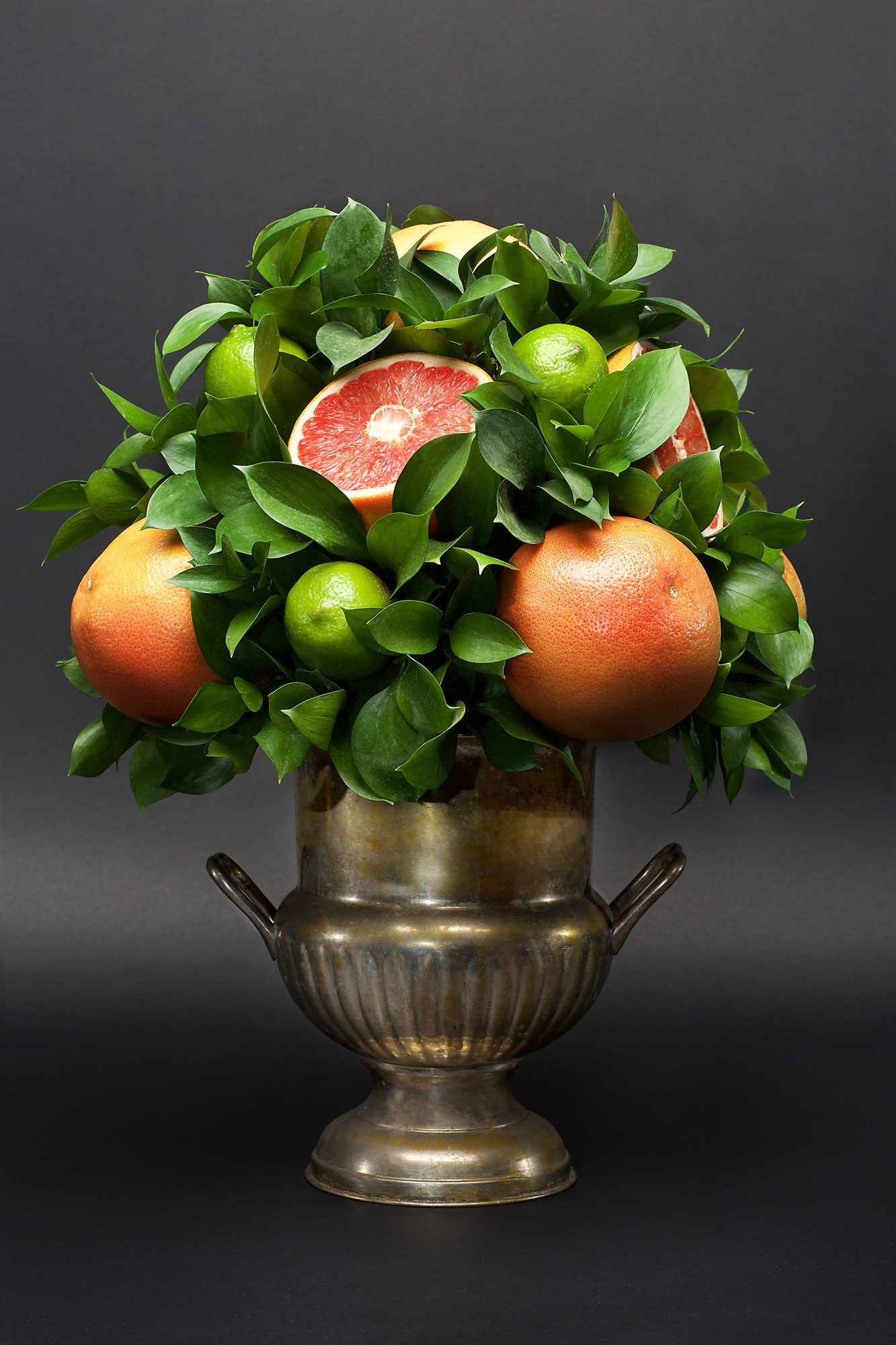 citrus centerpiece grapefruit limes leaves silver vase