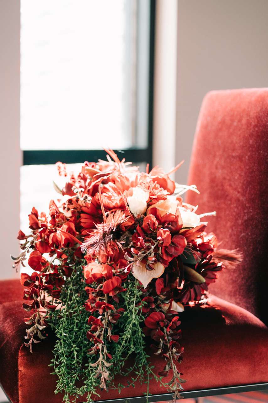 unique wedding color palette red chair by window red bouquet