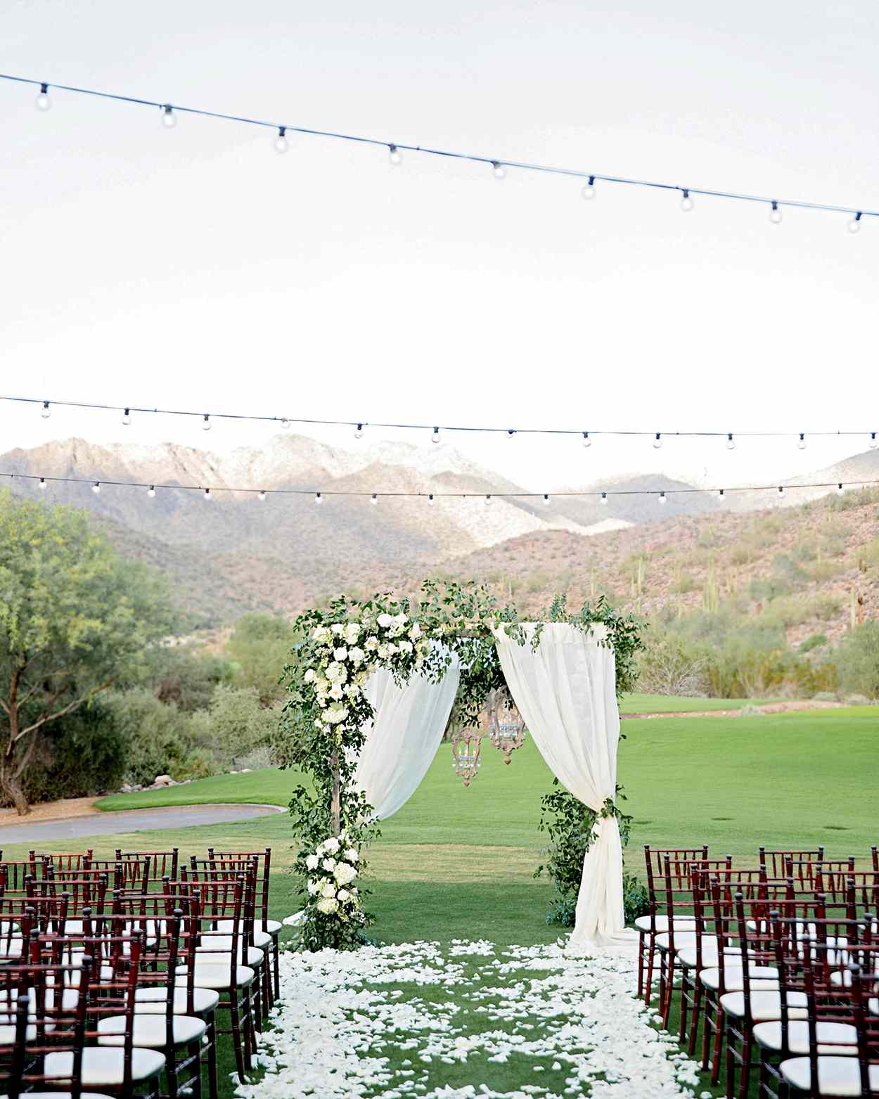 outdoor ceremony arch with tulle and greenery