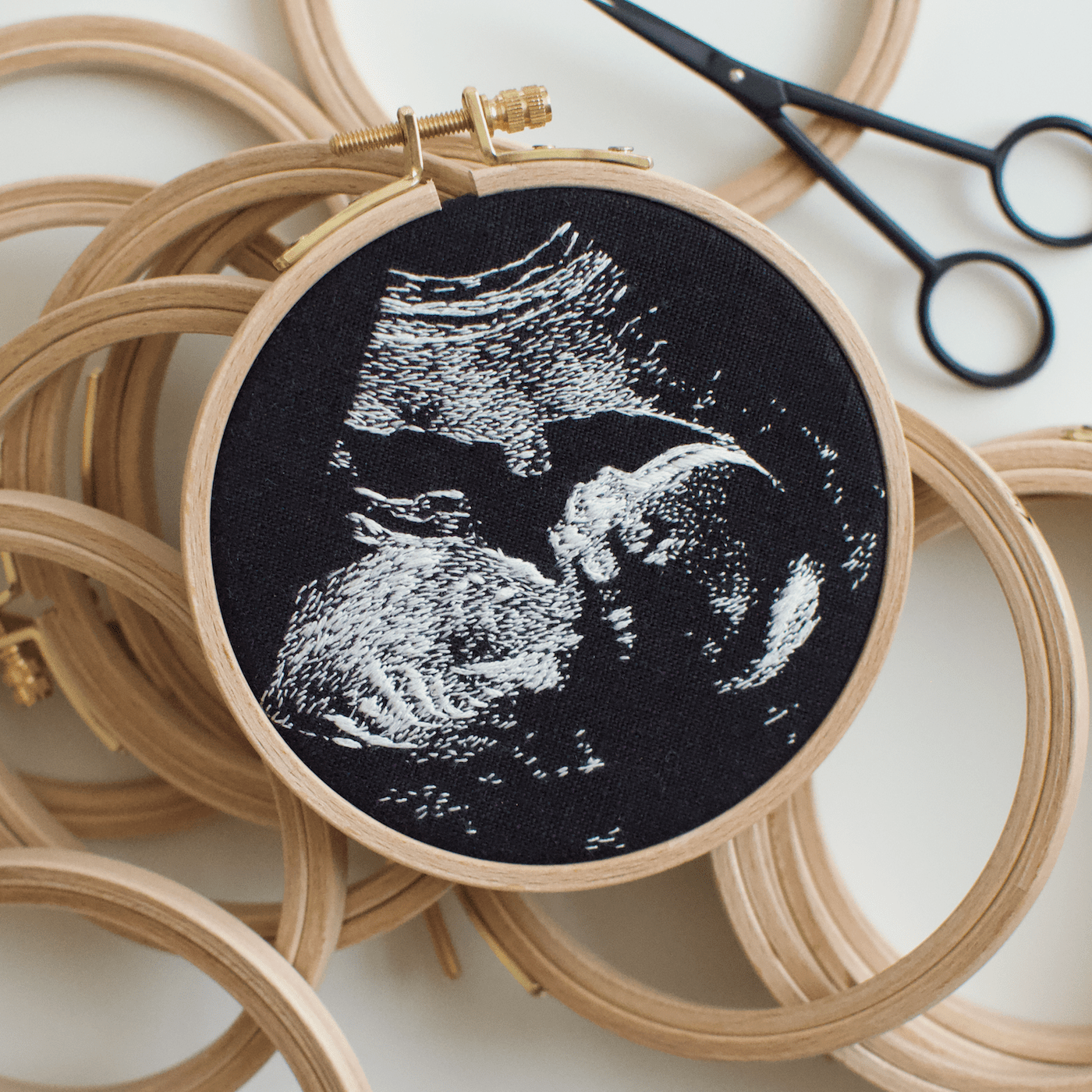 Embroidered sonogram imagery in a hoop.