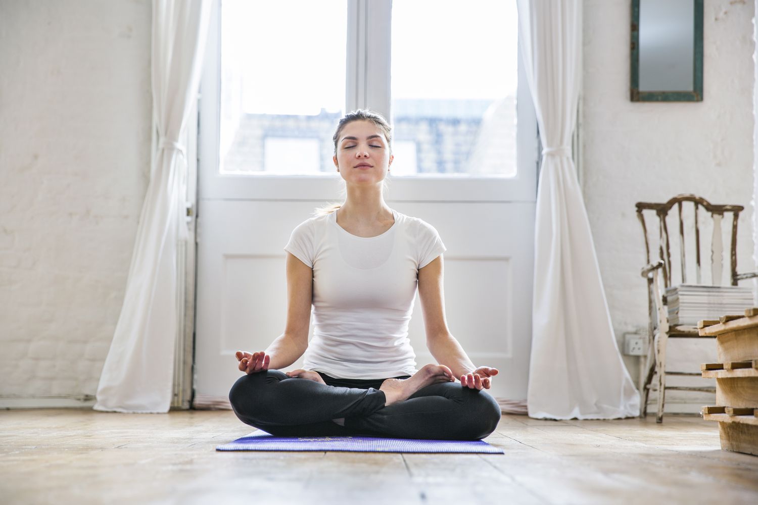brunette woman meditating on yoga mat