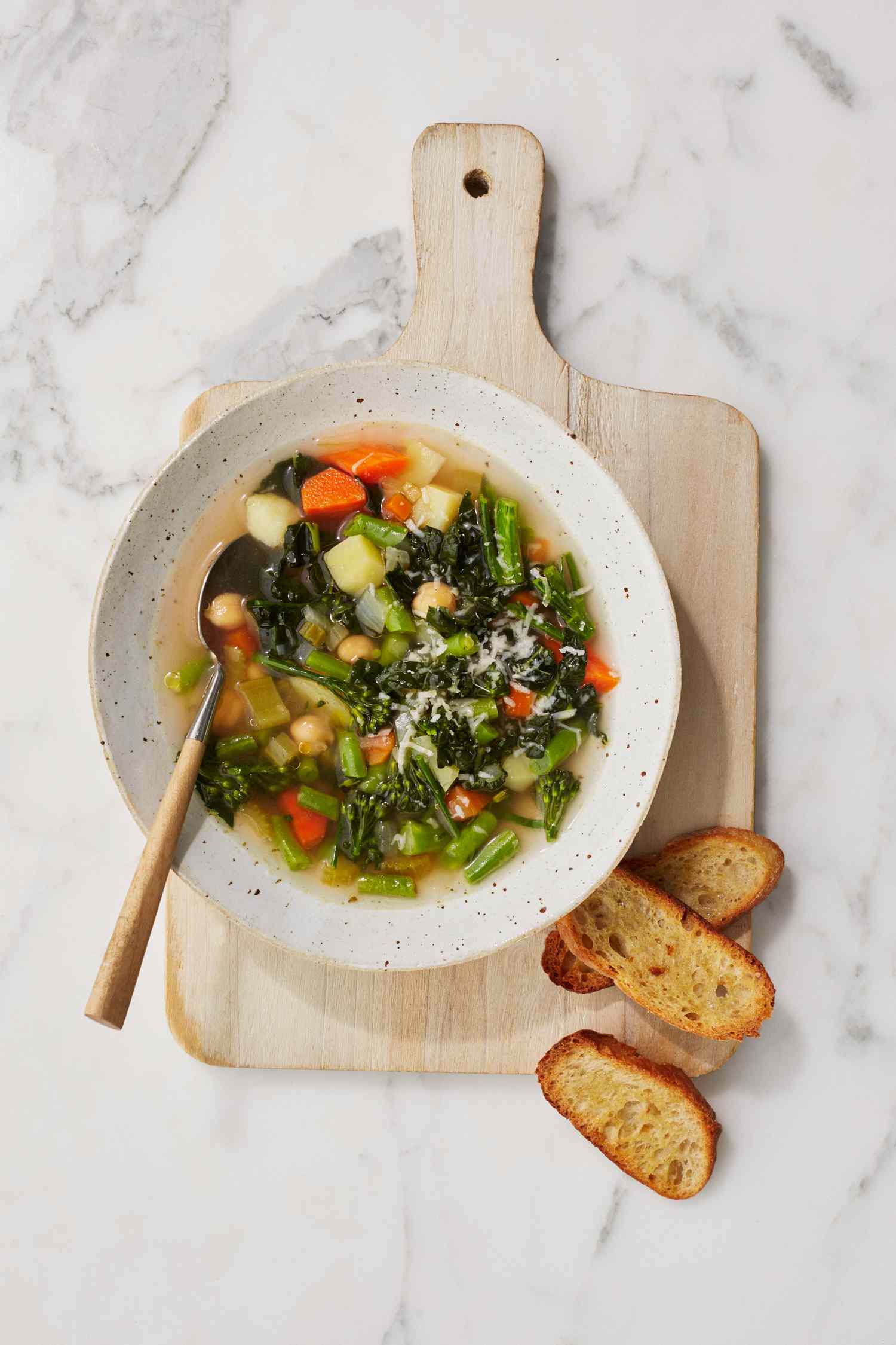 homemade vegetable soup with toasted bread on cutting board