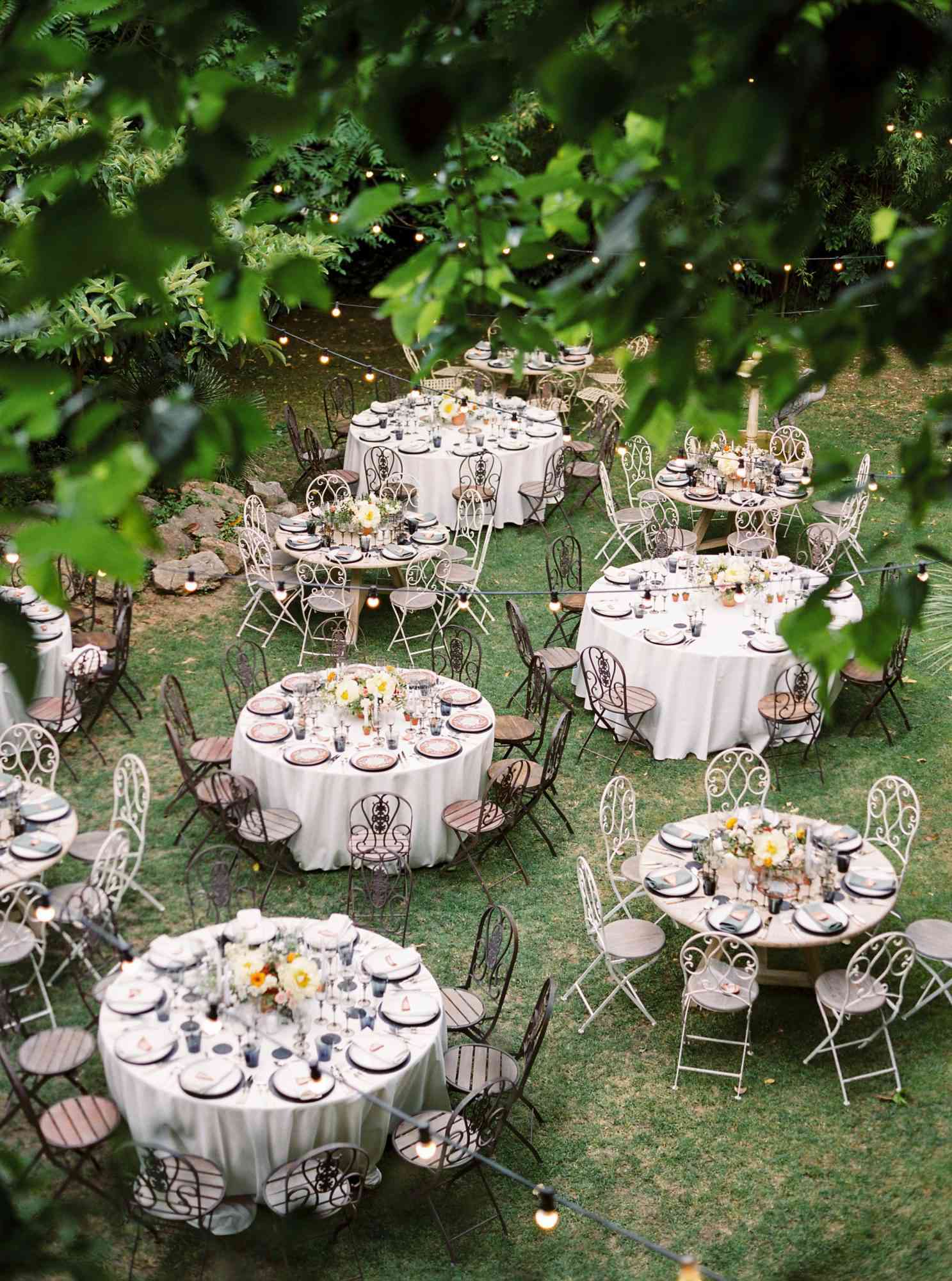 outdoor reception setup with round tables black and white chairs