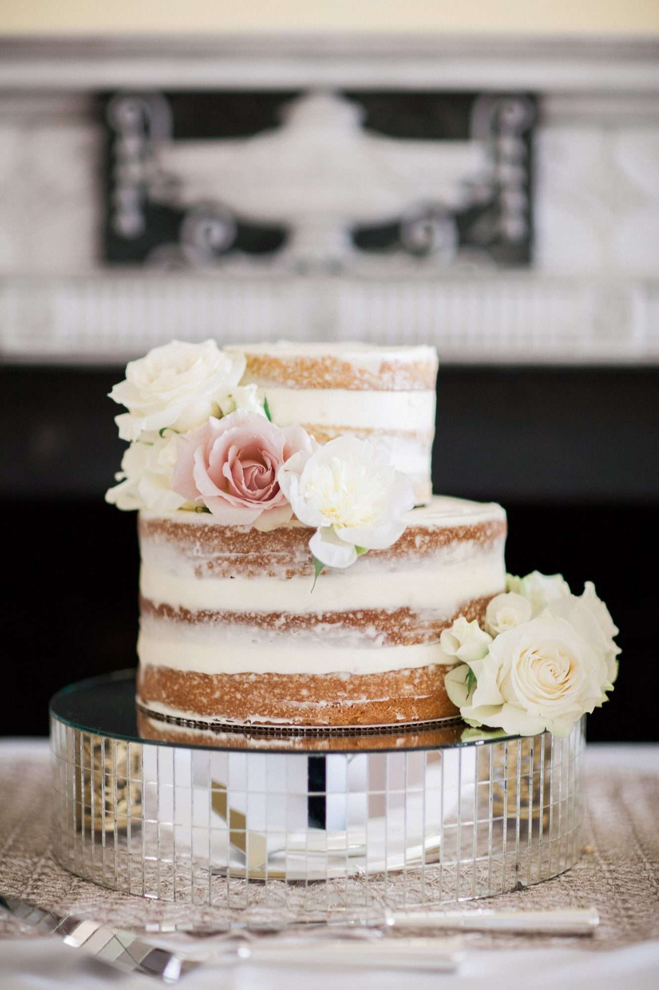 wedding cake sitting on mirrored pieces base