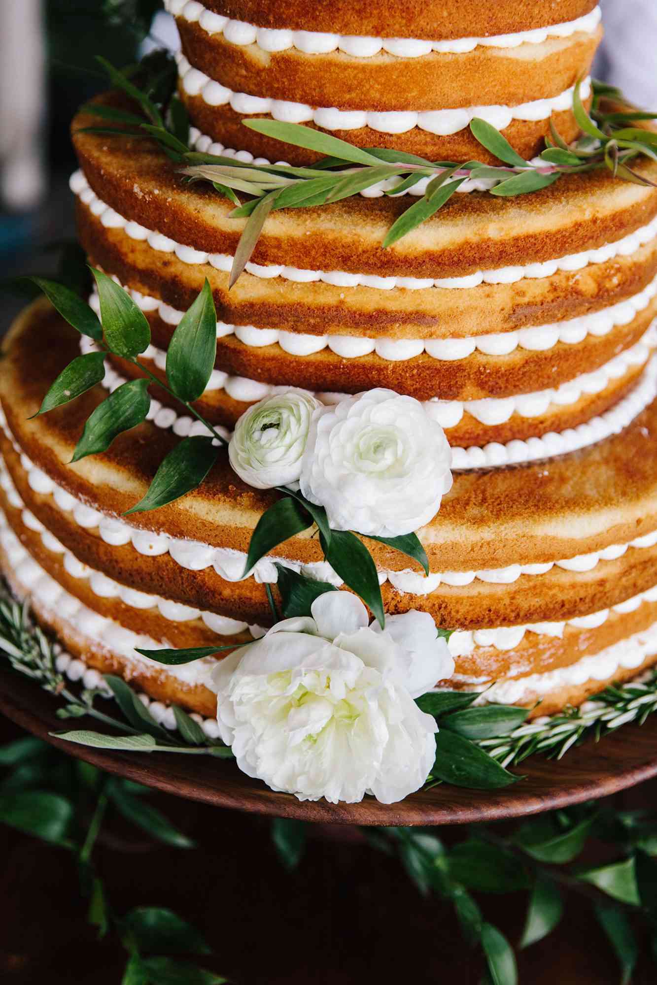 scalloped wedding decor naked cake with white flowers